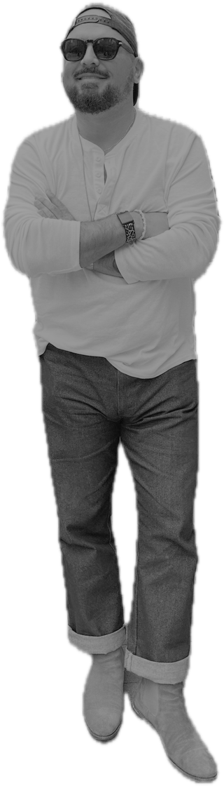 Dennis Ayotte, arms crossed, in a henley and jeans